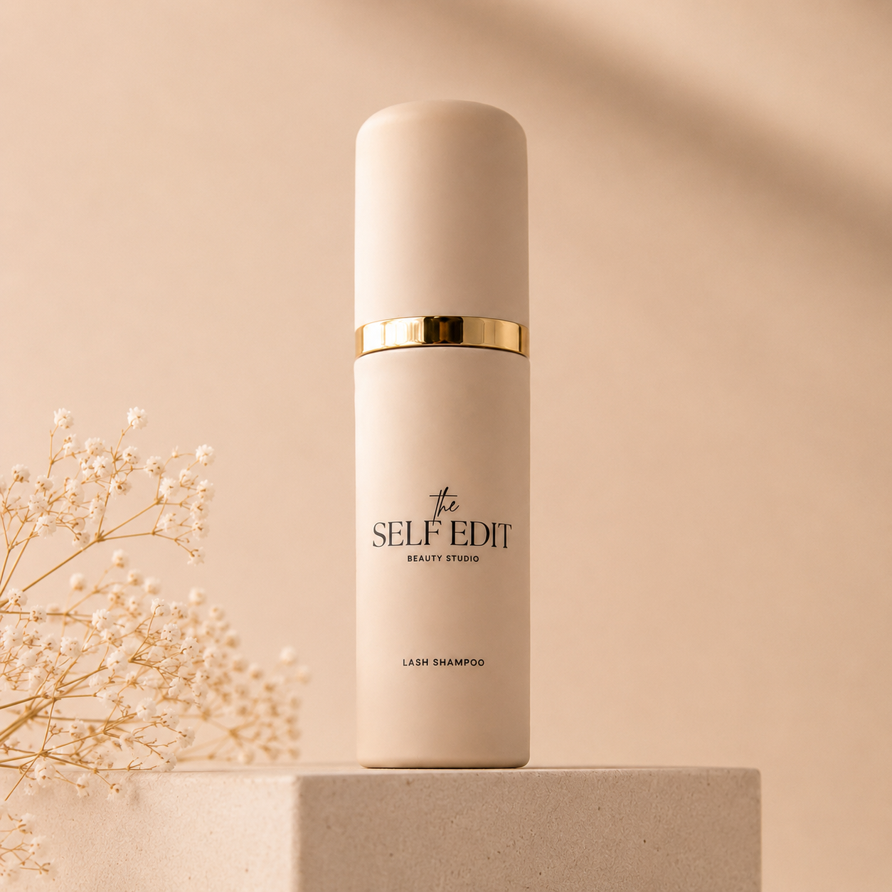 The Self Edit lash shampoo bottle on a stone pedestal
